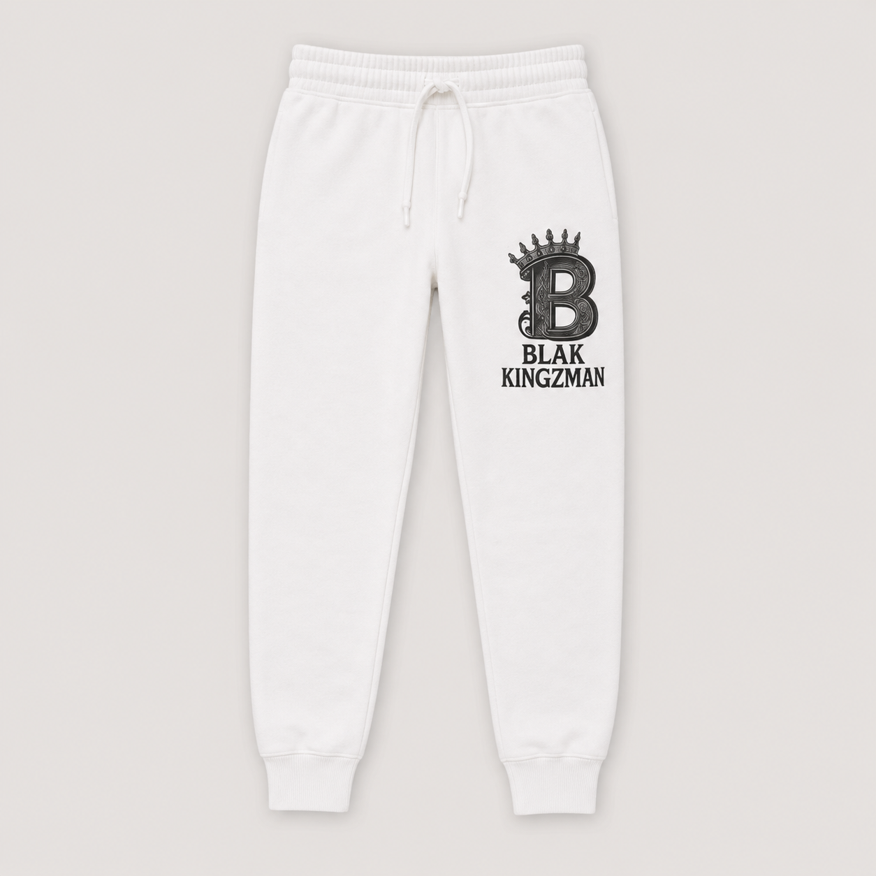BLAK KINGZMAN Crowned B White Joggers — white fleece jogger pants with ornate crowned B monogram and BLAK KINGZMAN lettering on the left leg