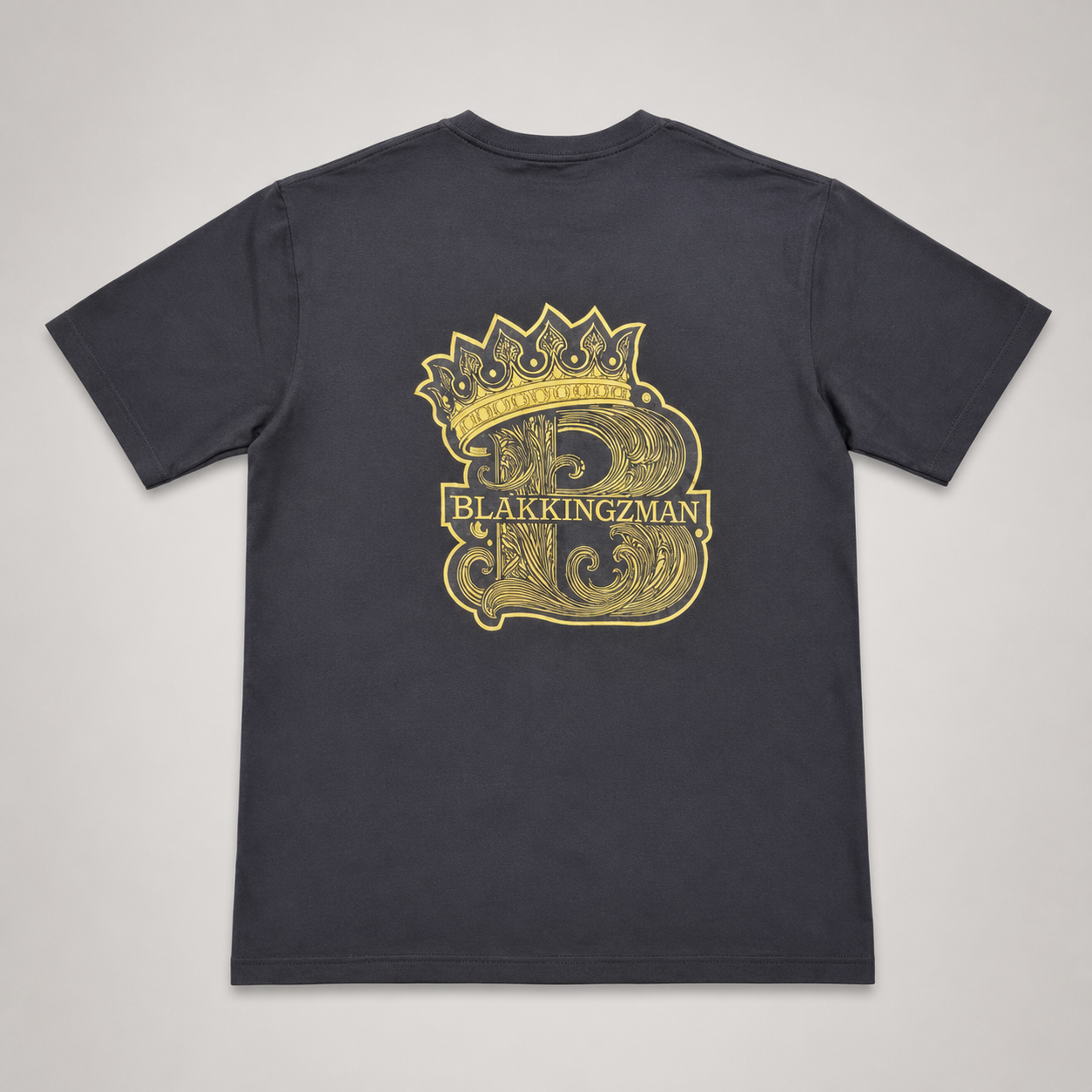 BLAK KINGZMAN Gold Crowned B Black Tee — large gold crowned B crest back print on dark charcoal unisex tee
