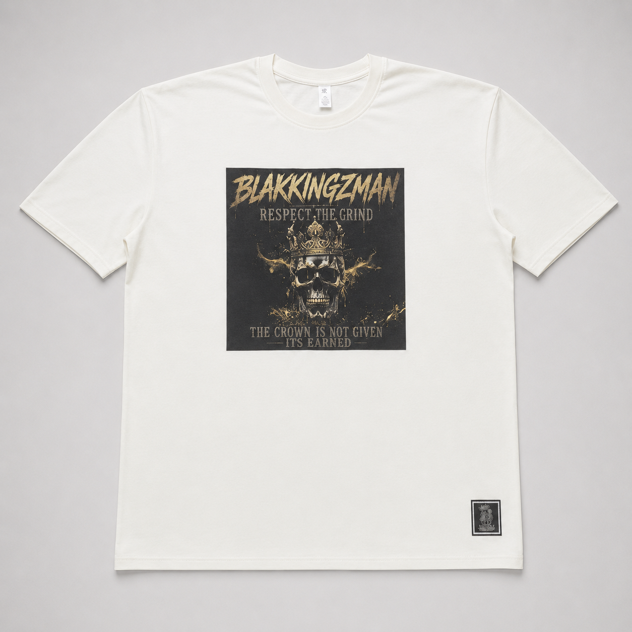 BLAK KINGZMAN Respect the Grind Crowned Skull White Tee — square dark-panel graphic with gold crowned skull on cream unisex tee